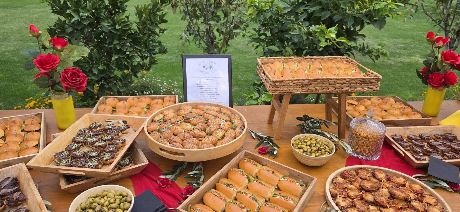 Buffet champêtre dressé au jardin : mini-burgers, planches catalanes et roses rouges